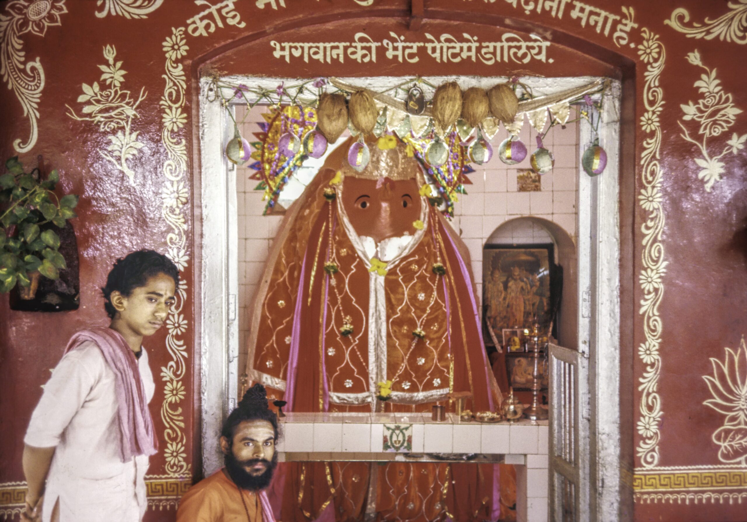 A Hindu priest and helper in front of the monkey god