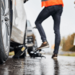 People exchanging information after car accident on wet road in Alabama, showing proper steps for filing insurance claim.