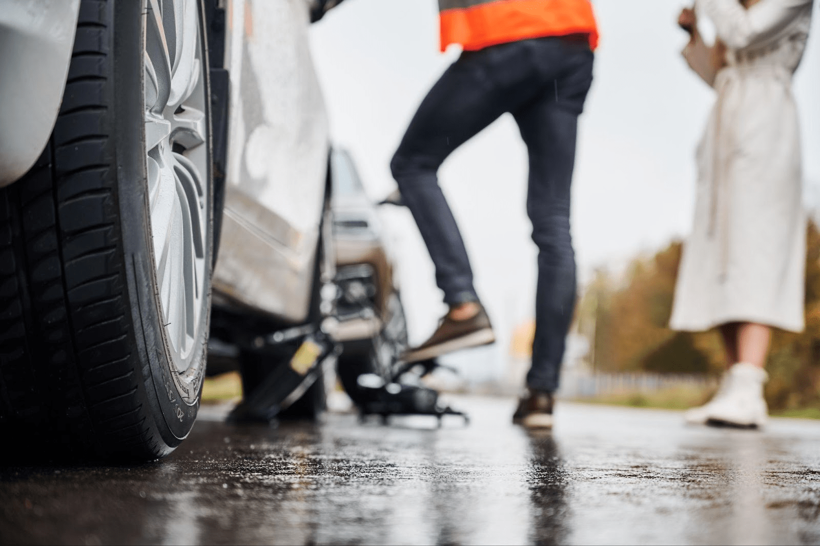 People exchanging information after car accident on wet road in Alabama, showing proper steps for filing insurance claim.