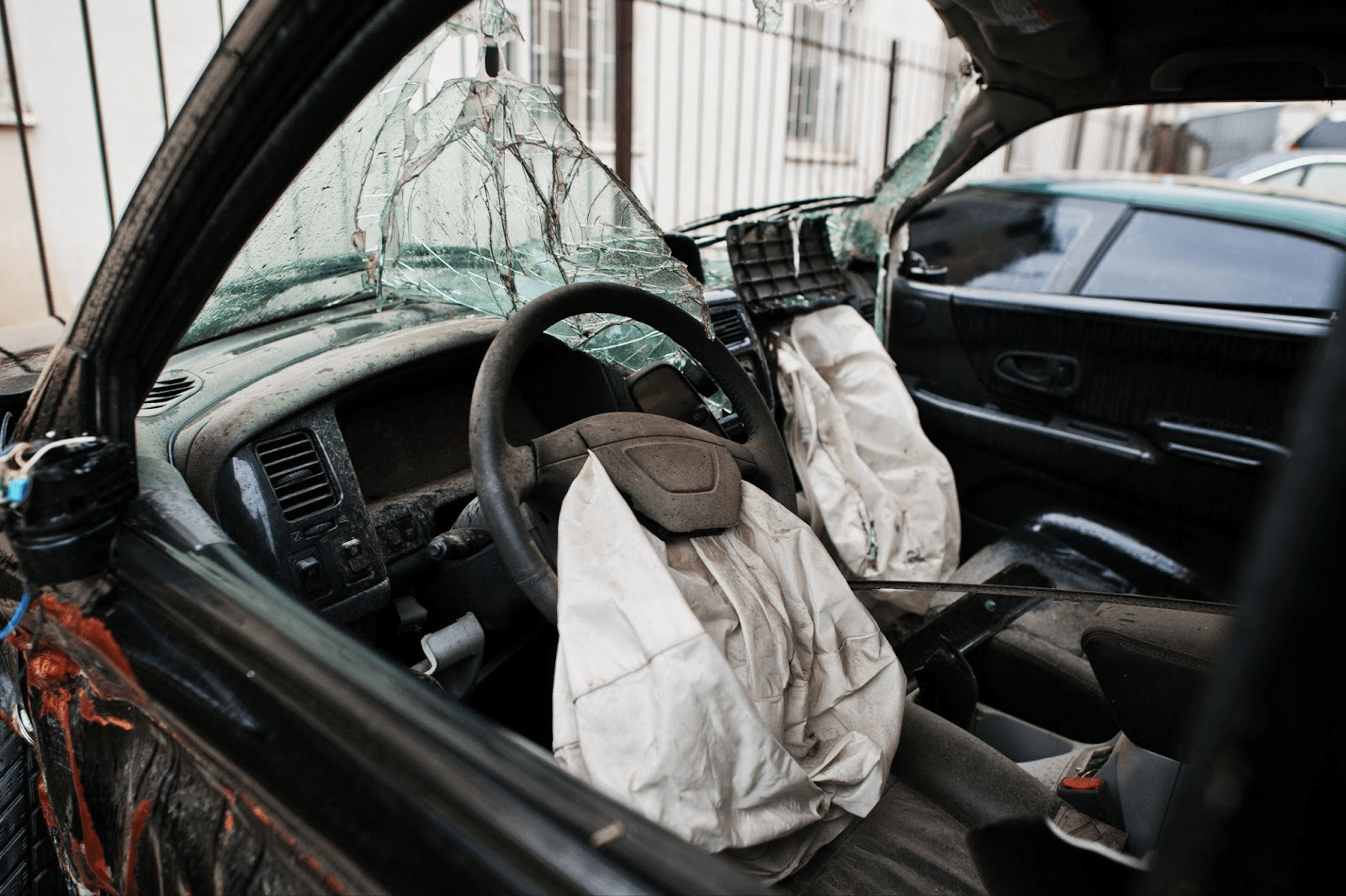 Severely damaged car interior with deployed airbags and shattered windshield showing typical timeline from Alabama crash to settlement.