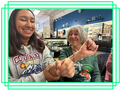 Big and a Little, showing off the beaded bracelets they're making together.