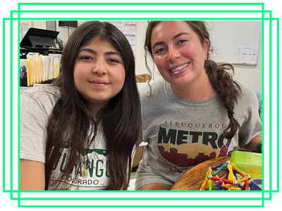 Big and Little, smiling for the camera as they work on a creative project together.