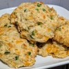 Cheddar Jalapeno drop biscuits in a pile on a white plate.
