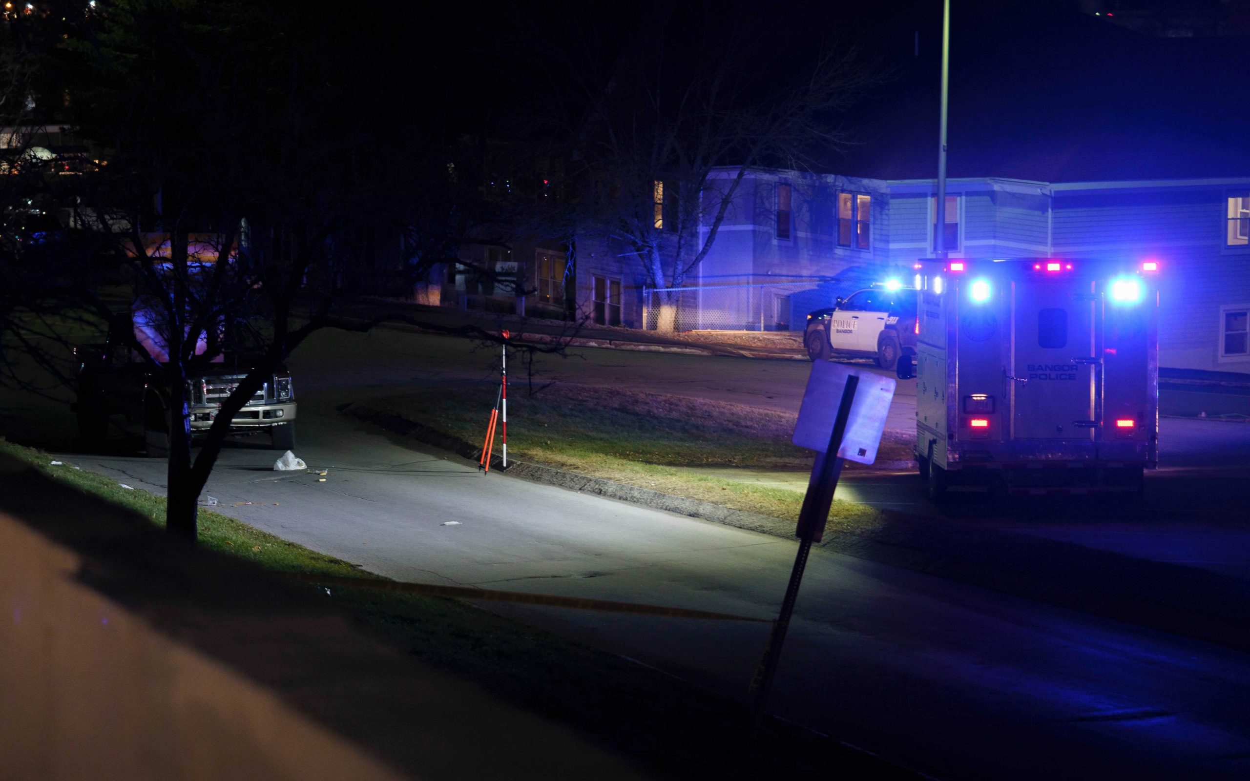 Police lights illuminate the scene of a crash on a city street, including a pickup truck.