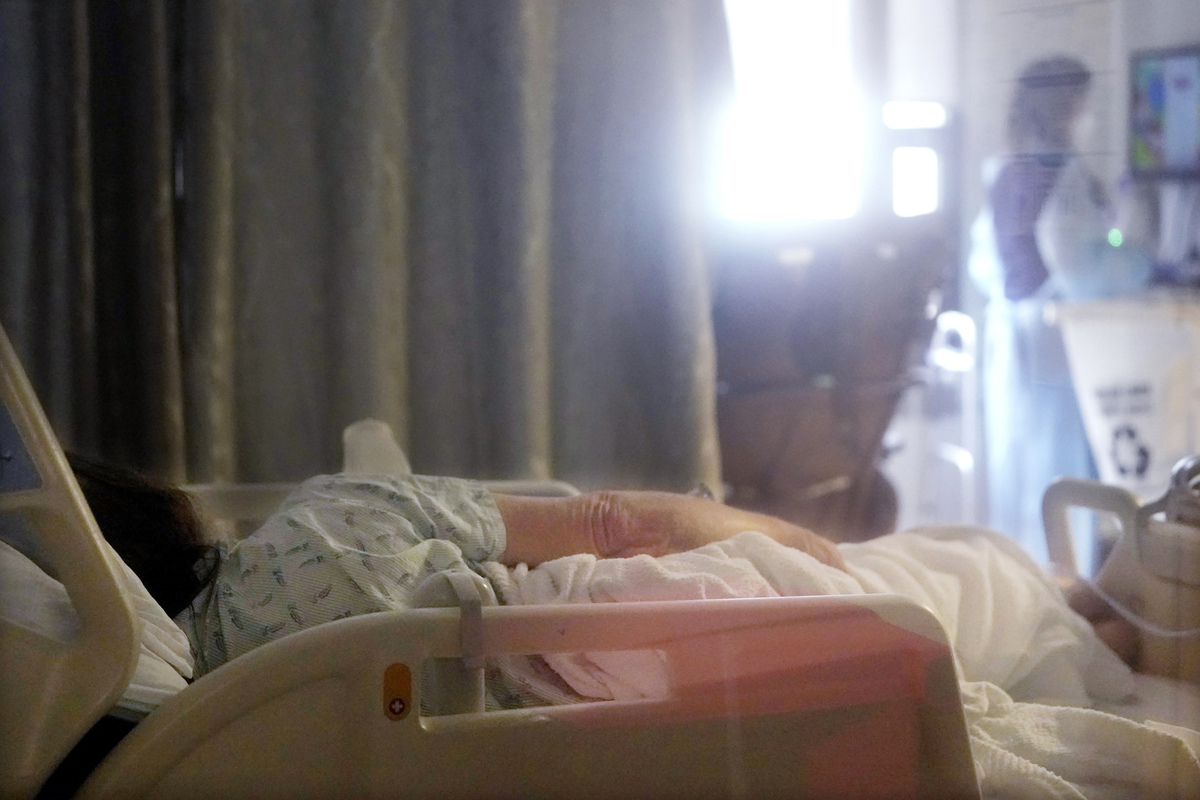 A hospital patient lies in a bed.