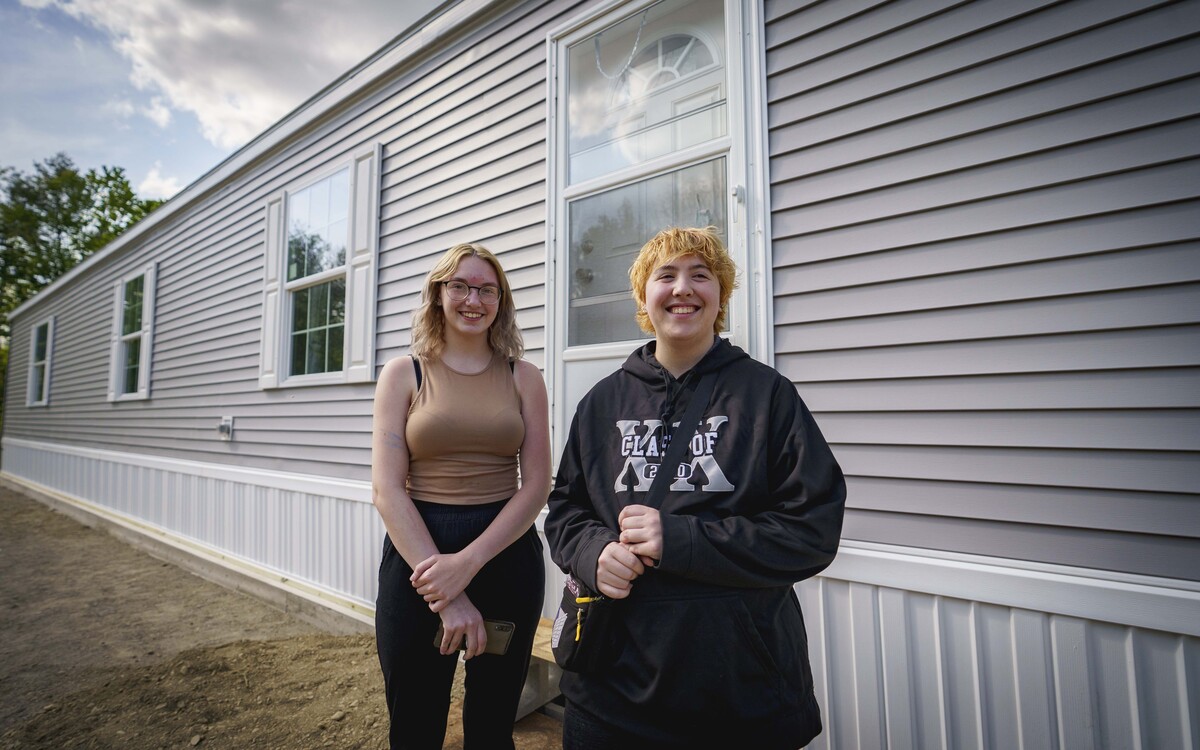 Sisters Devyn and Jordyn Robinson stand in front of their new home.
