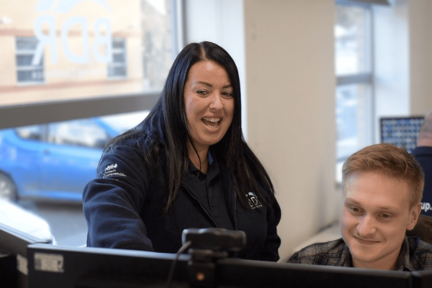 A photo of Danielle Fairless, our Head of Telecoms, helping a telecoms engineer at our head office
