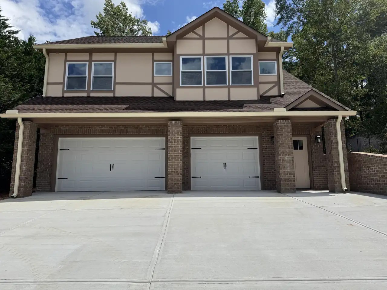 Two-story garage addition with brick base and Tudor-style stucco upper level