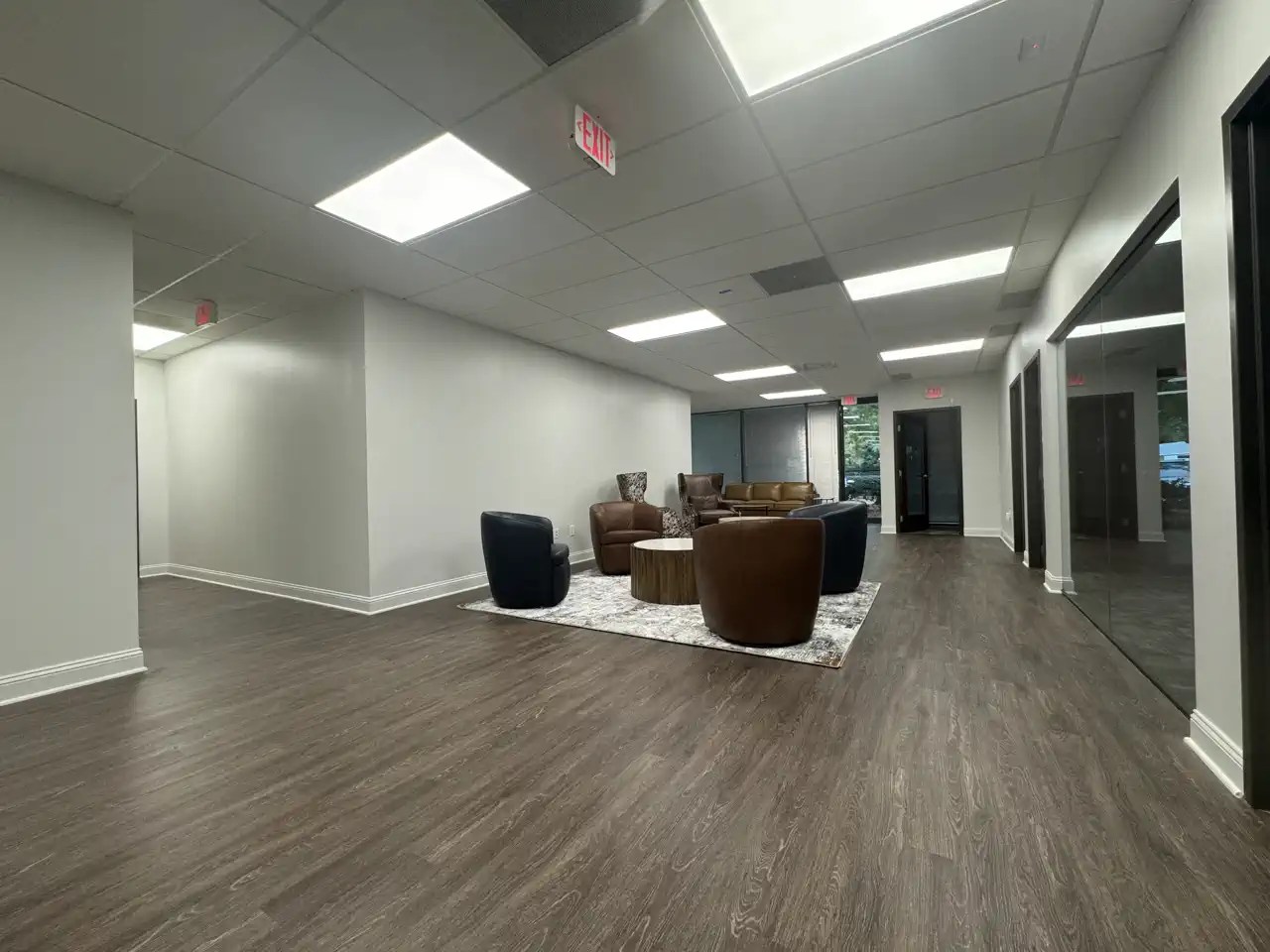 Open office lounge with leather chairs, coffee table, and natural light