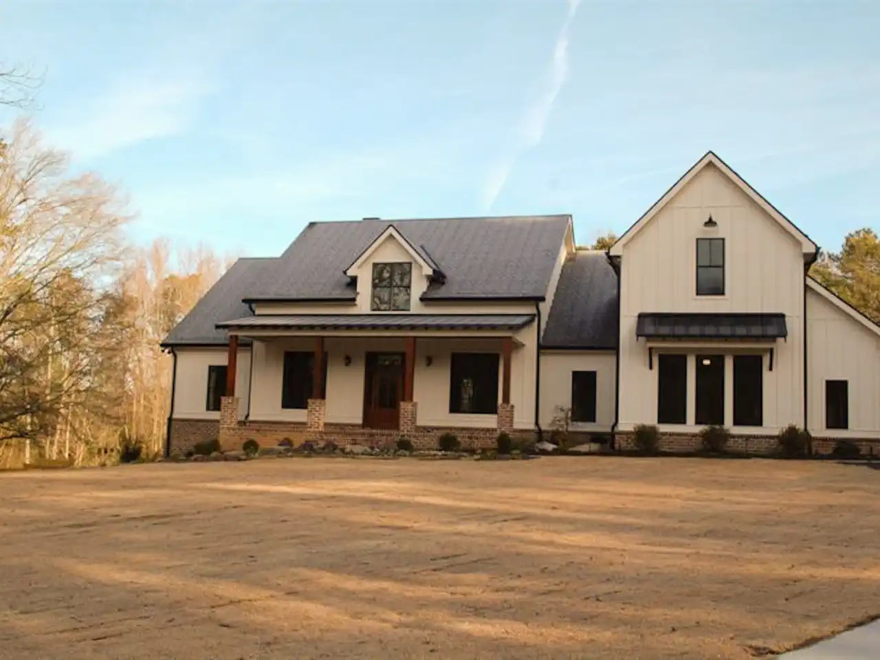 White farmhouse-style home with black-trimmed windows and board and batten siding