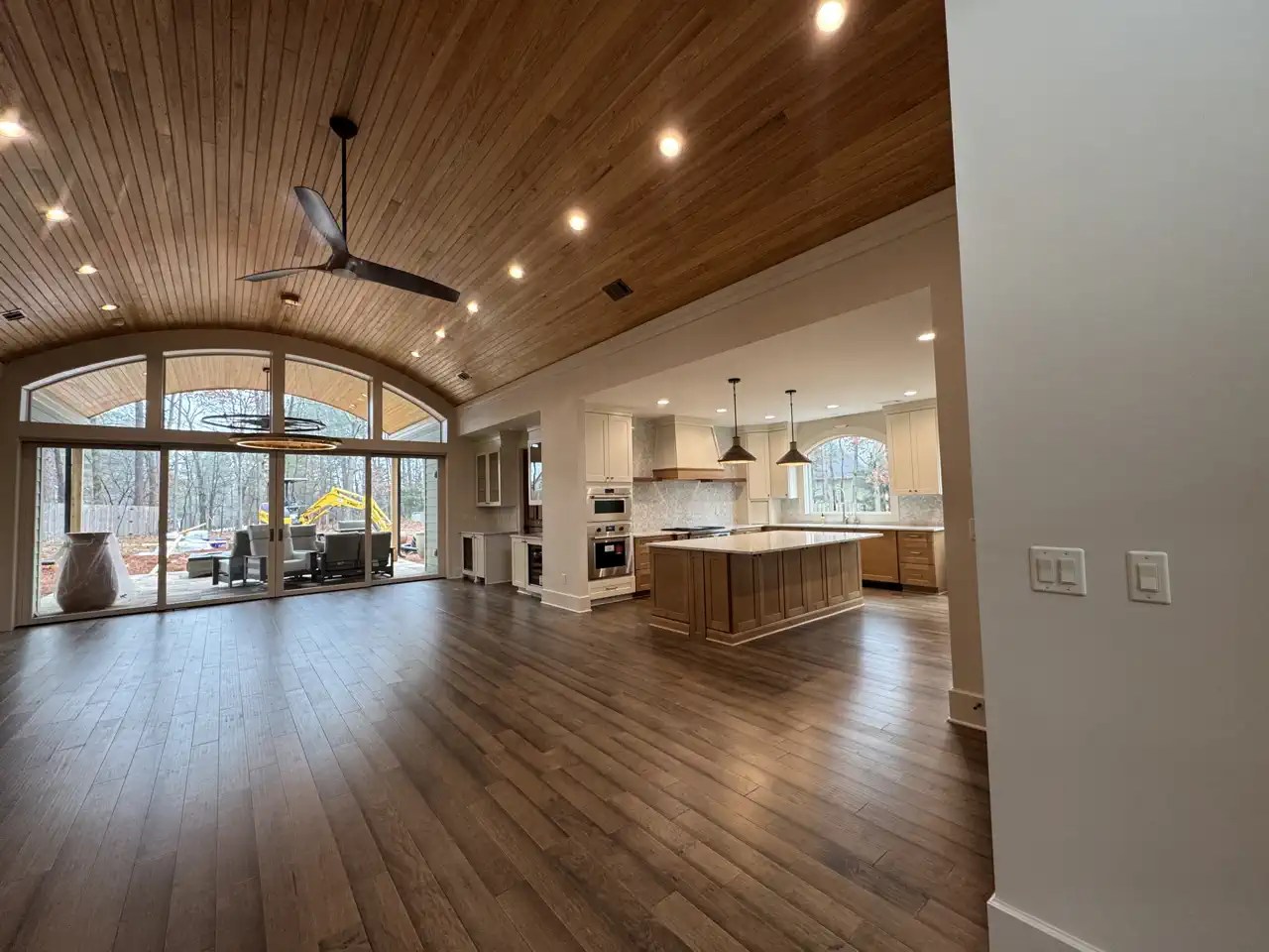 Great room with vaulted wood-paneled ceiling opening into an updated kitchen