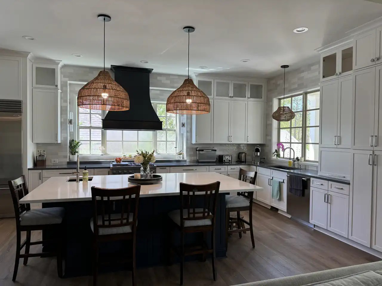 White kitchen with navy island, prep sink, and family seating for four