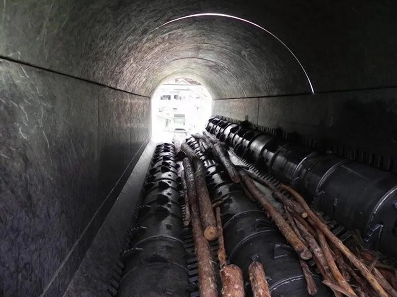Logs are debarked inside a rotary debarker.