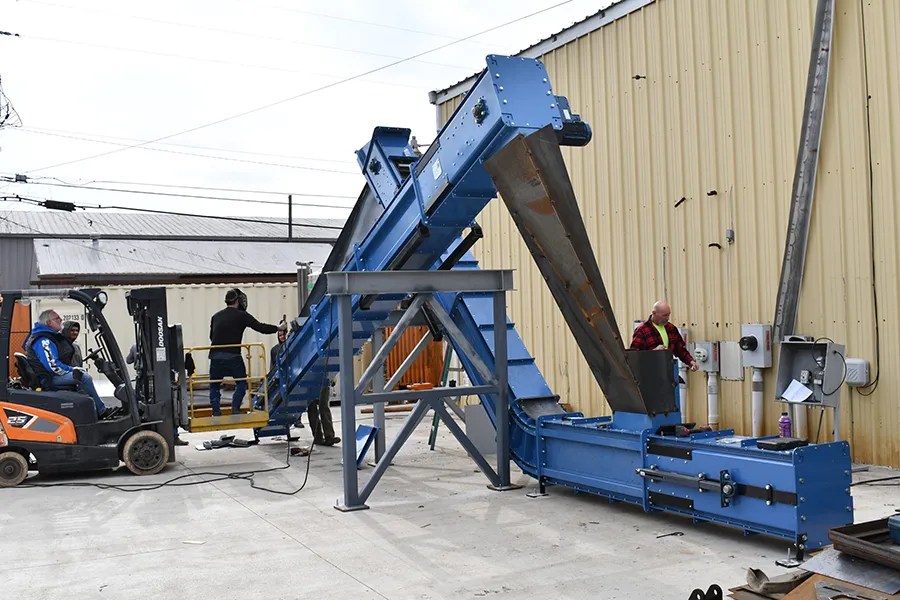 Crews construct a test carousel conveyor.