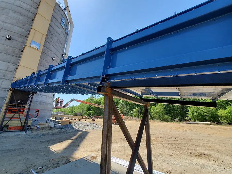 An enclosed drag conveyor feeds a bucket elevator.