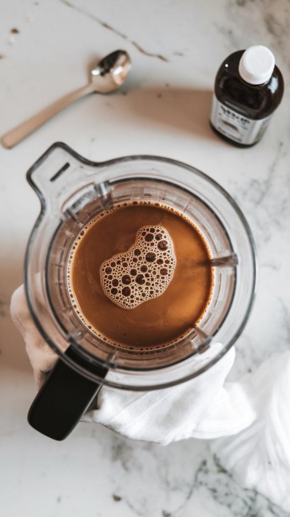 a blender with peanut butter milk mixture, now combined with dark cold brew coffee, maple syrup, and vanilla extract