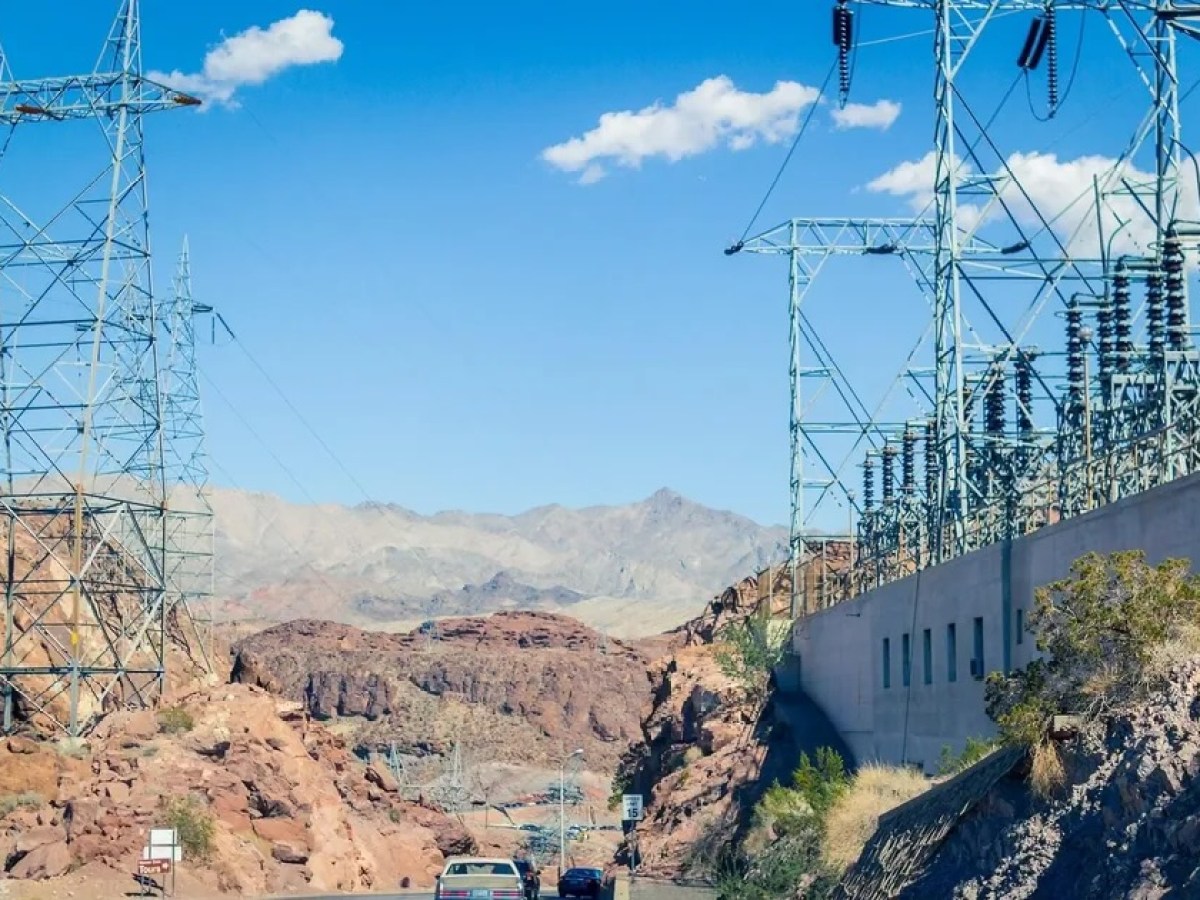 High-voltage transmission towers and a substation beside a desert highway