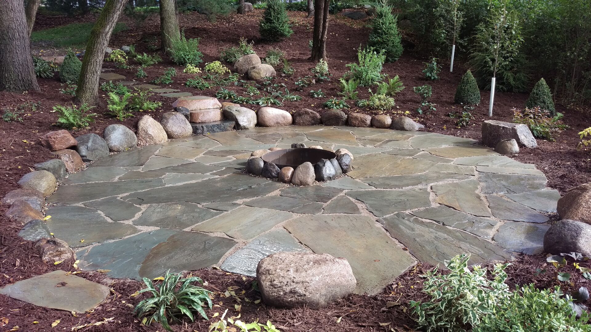 A stone patio featuring beautiful custom fire pits