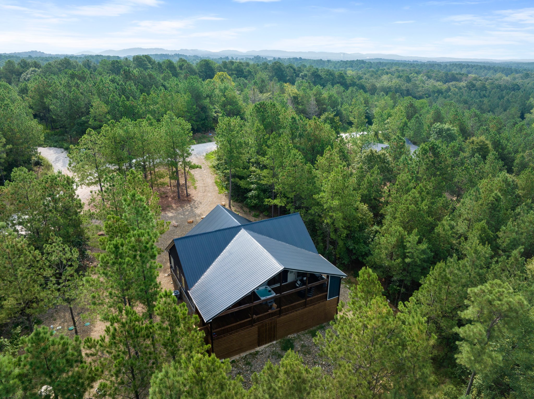 Aerial view of Beds, Boating & Beyond cabin surrounded by pine forest in Hochatown