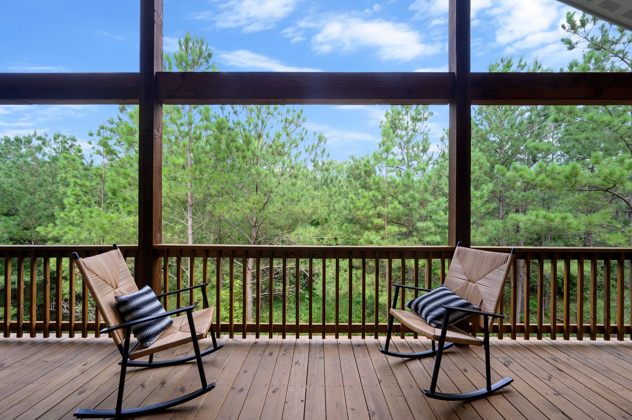 Rocking chairs on the covered back deck overlooking the pine forest