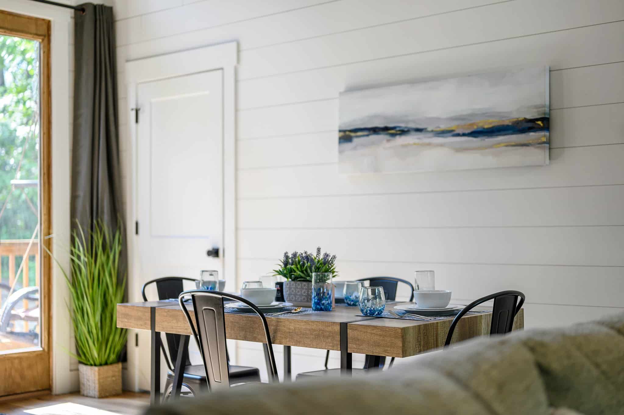 Dining table beside the windows in the open-concept living area