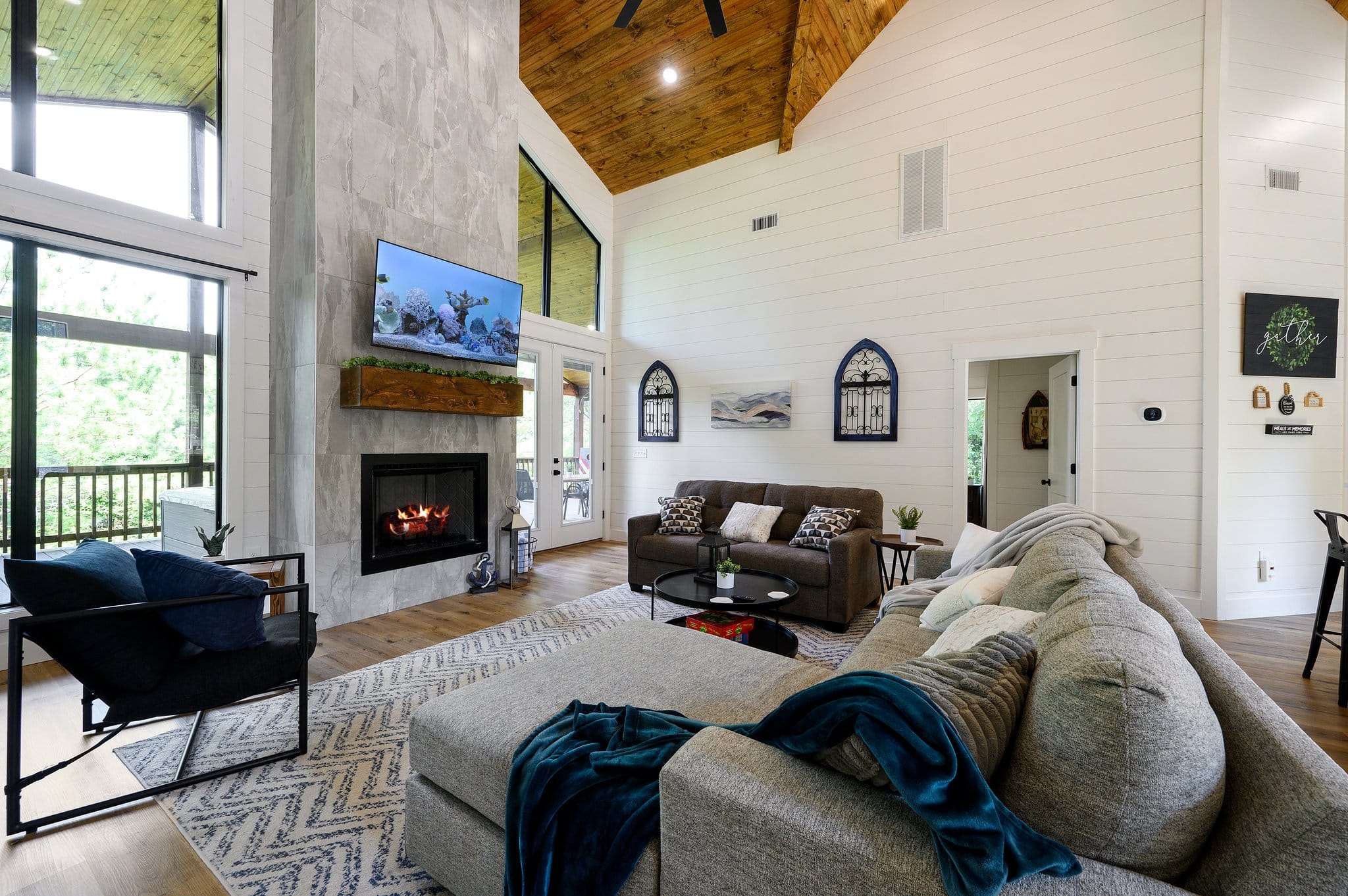 Open-concept living room with sectional seating, fireplace, and vaulted ceiling