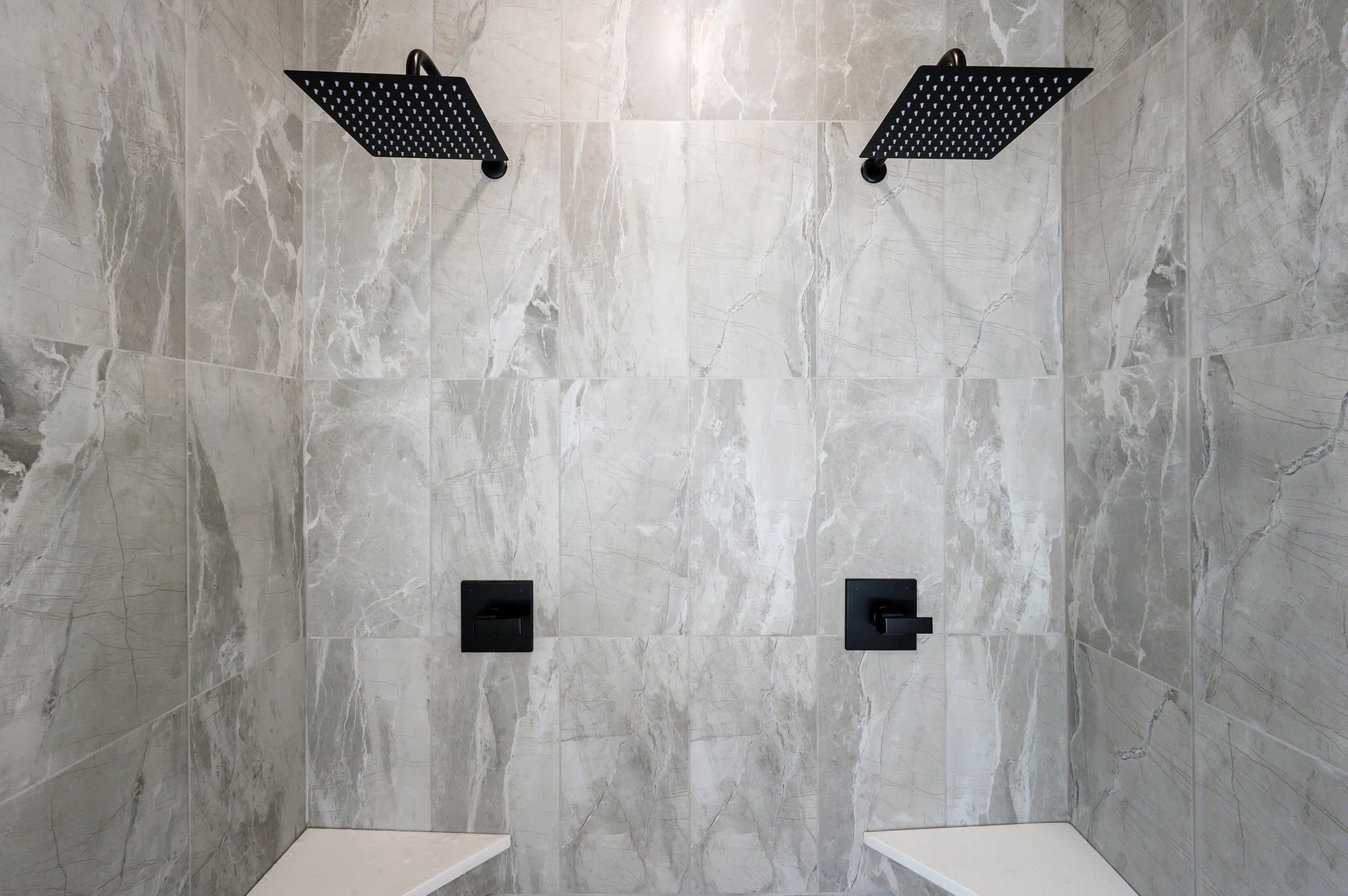 Walk-in tiled shower with dual rainfall showerheads