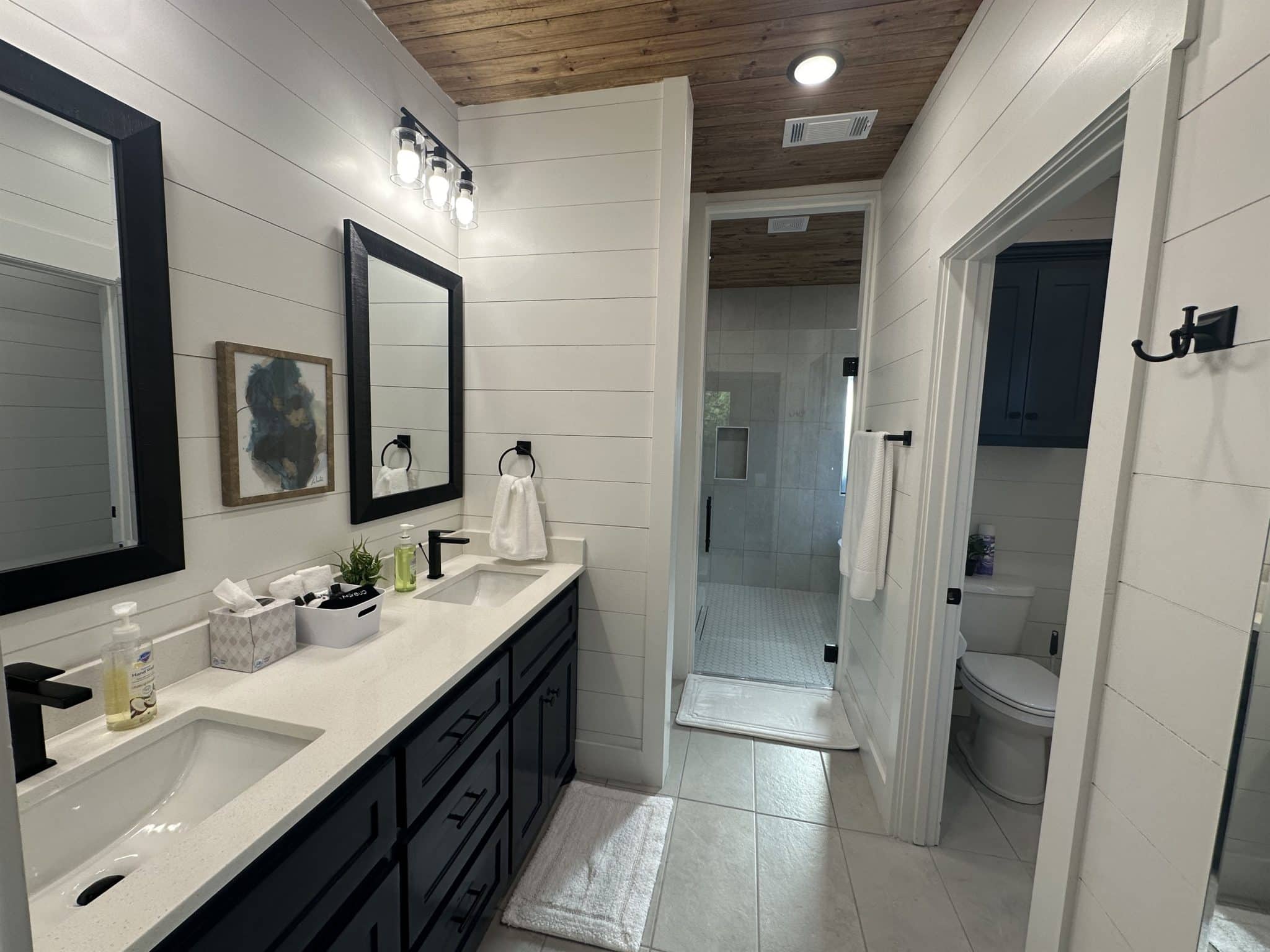 Dual sink vanity, shower glass door, toilet room