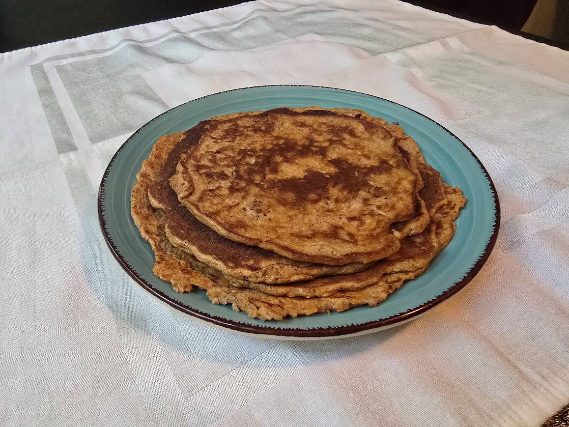 Stack of homemade sweet potato protein pancakes served on a blue plate for a high-protein breakfast