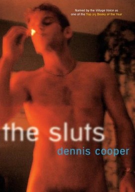 Cover of Dennis Cooper's The Sluts. A naked man with torso visible lights a cigarette. The cover is toned a reddish orange and is blurred in a way that suggests a distorted photograph or computer screenshot.