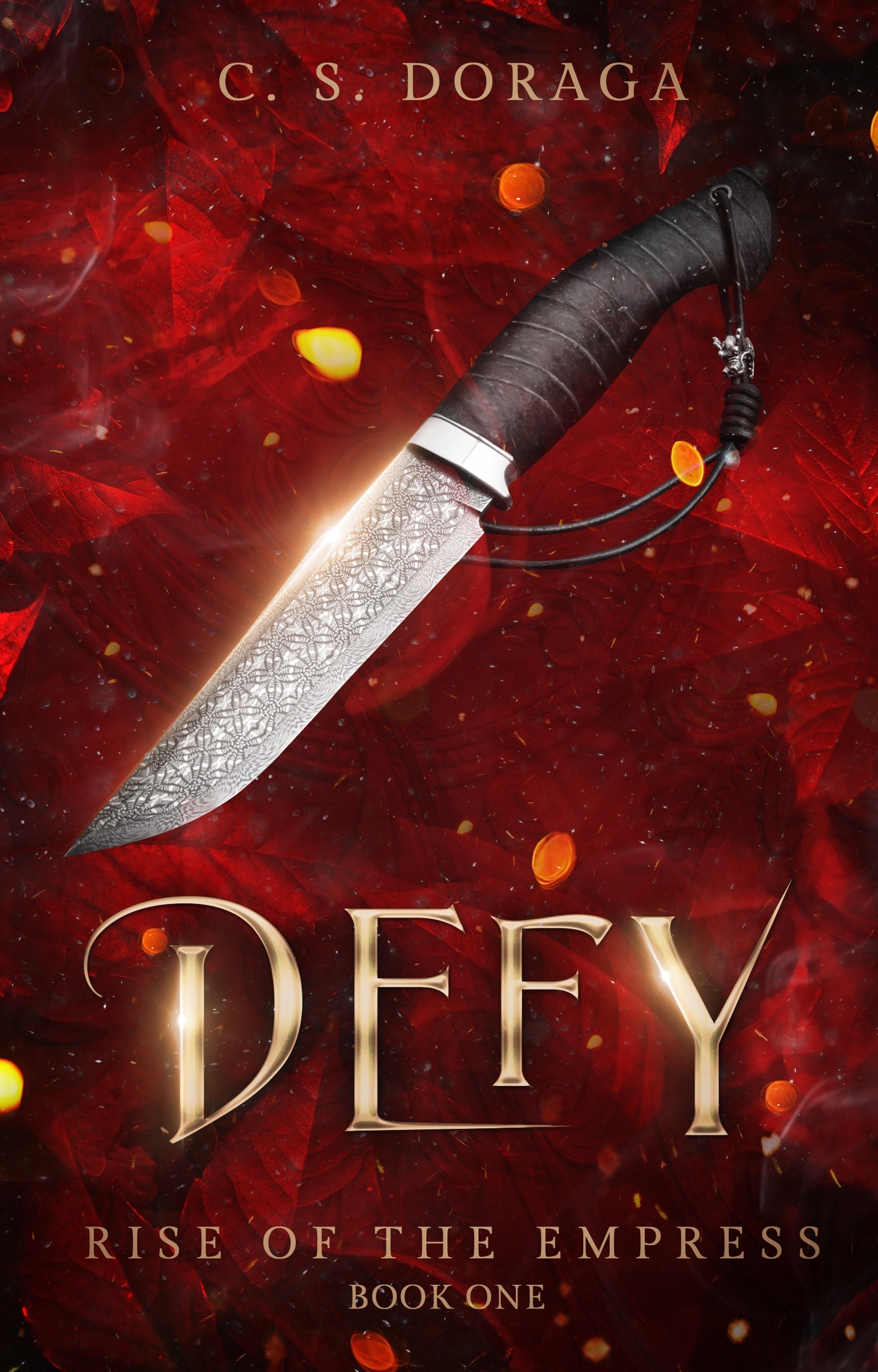 Cover of Defy by C. S. Doraga. A slightly curved dagger with a beaded loop attached to the hilt is lit from behind by vibrant red smoke and little drops of orange and yellow. The entire cover has a warm, intense glow and the title is embossed with gold.