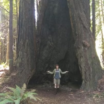 Photo of author T. C. Duck in front of a very large tree with an impressive hollow