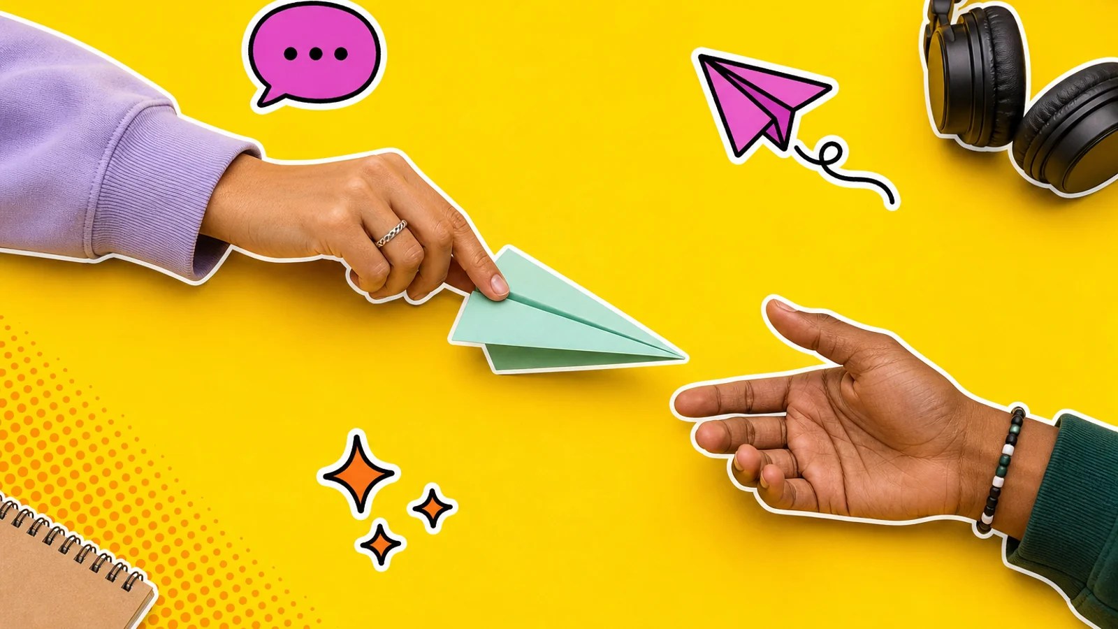 Two adults’ hands pass a blank paper plane across a casual tabletop with headphones and a sketchbook nearby