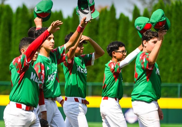 Cuatro jóvenes beisbolistas con uniforme verde y blanco de México celebran en el terreno, levantando sus gorras verdes hacia el cielo