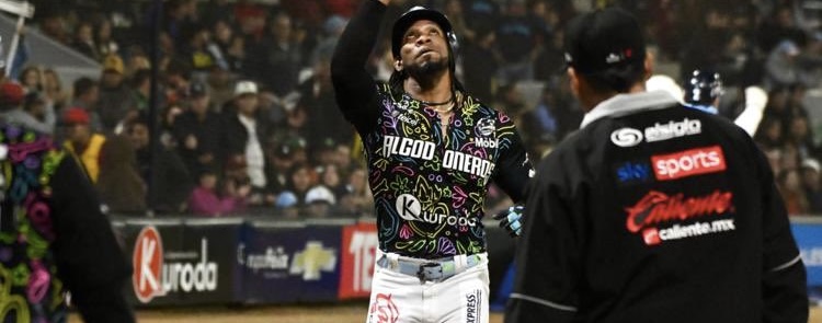 Pelotero con uniforme blanco y negro celebra con el puño levantado en un estadio de beisbol lleno de aficionados