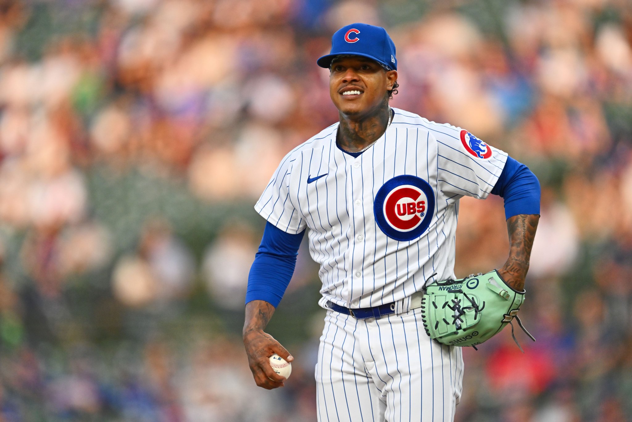 Lanzador de los Cachorros de Chicago en uniforme blanco con pinstripes, guante verde, durante un juego en el estadio