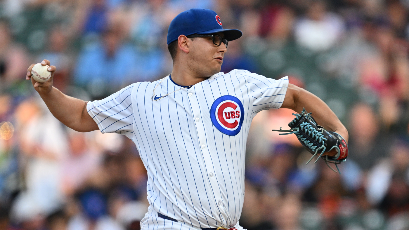 Lanzador de los Cachorros de Chicago en uniforme de rayas blancas lanza la pelota durante un juego