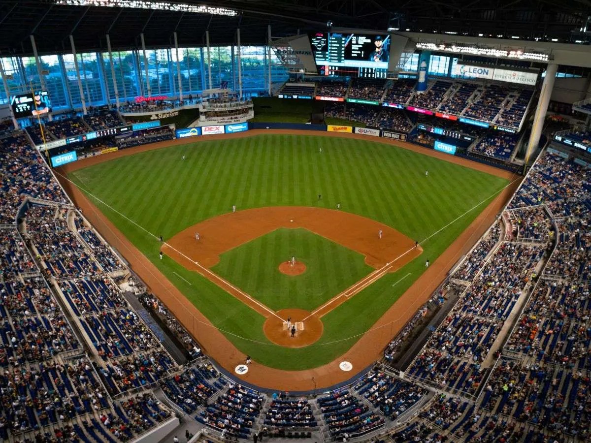 Vista aérea del estadio de beisbol lleno de aficionados, con el diamante, las bases y el jardín verde perfectamente visibles desde arriba