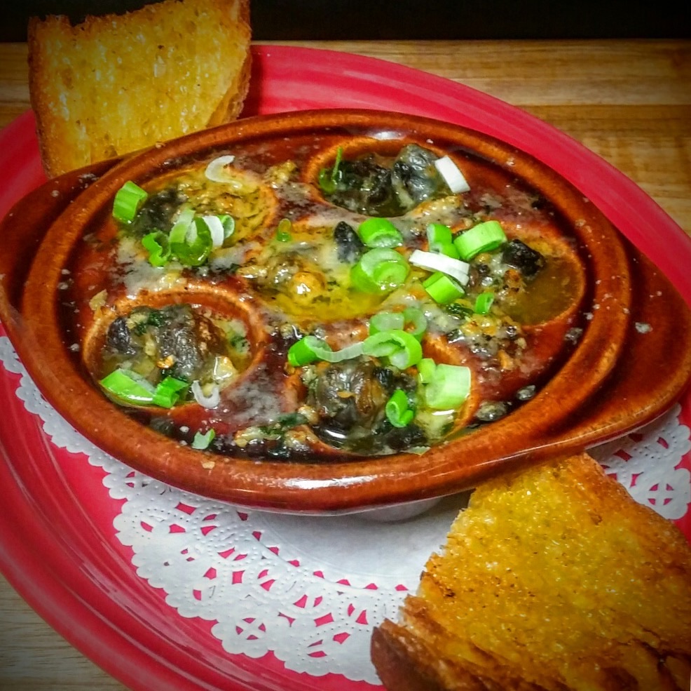 ESCARGOT - baked in garlic butter green onions and topped with Asiago cheese