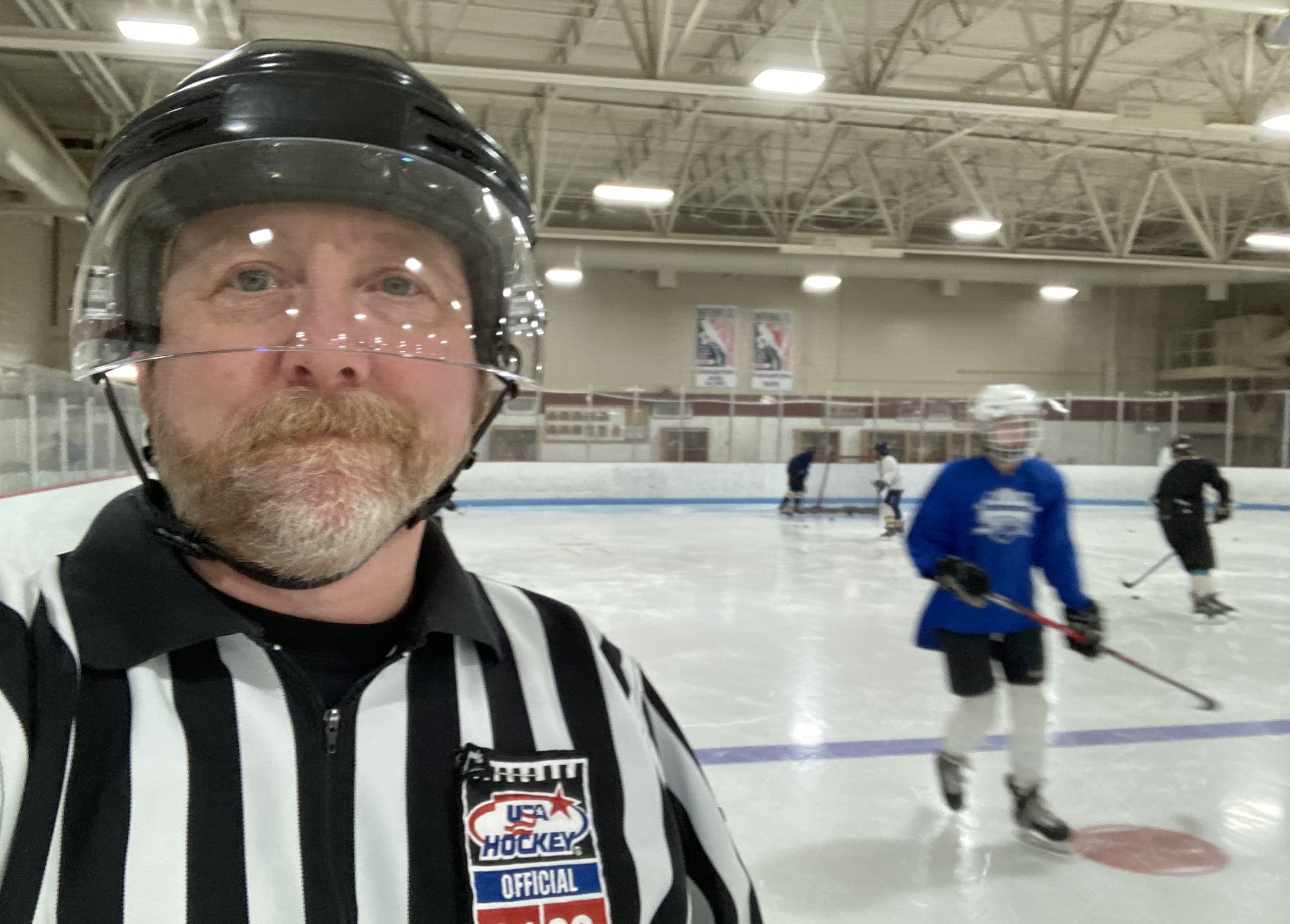Ben Harris in ice hockey referee uniform at ice arena.