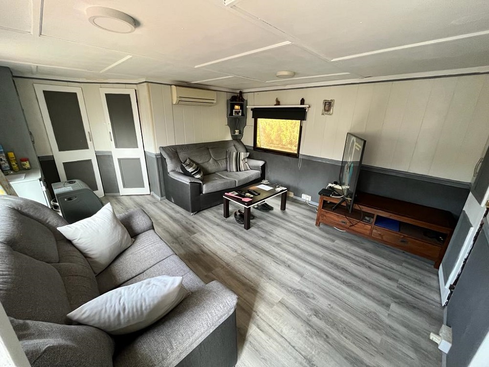 An image of a living room in a mobile home for sale on Camping Colmar Campsite in El Campello, Spain