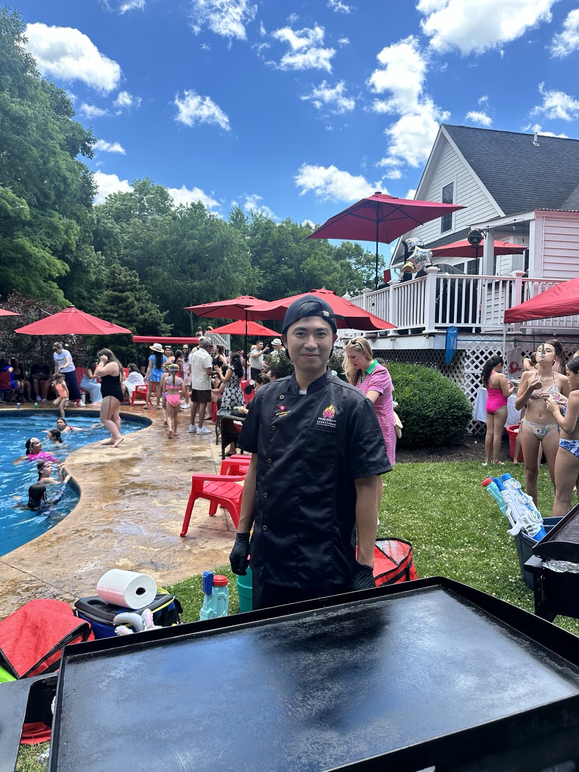 Private chef at the portable hibachi station with graduation party in the background in Monroe Connecticut