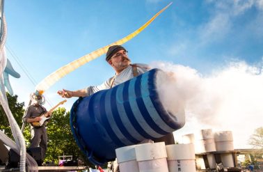Pneu08-John Altdorfer Man on stage behind smoking barrel
