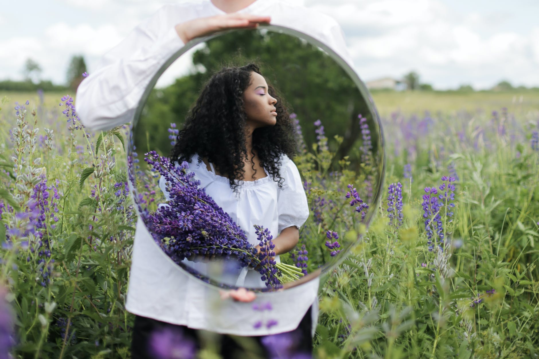 woman in white shirt holding purple flowers