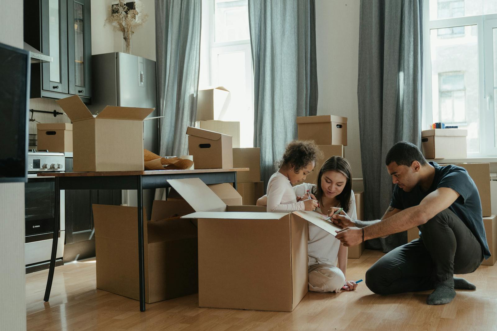 A family unpacks moving boxes in their new home kitchen, creating a cozy atmosphere. temporary housing, short term housing