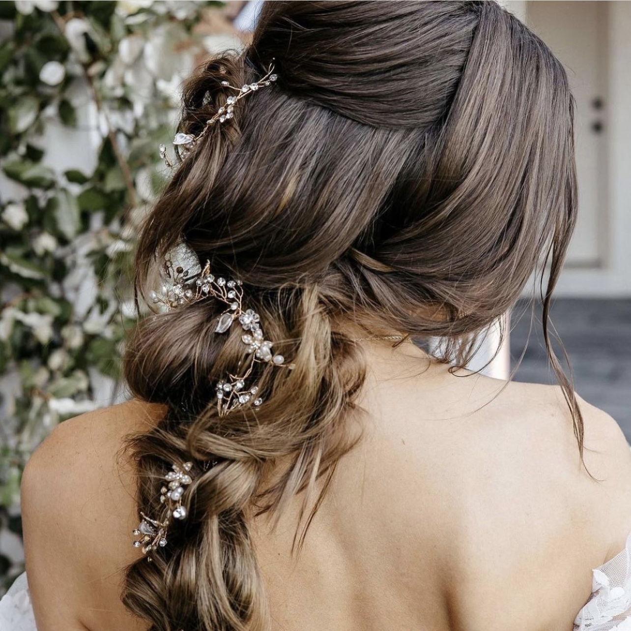 woman with brown hair with bridal loose briad with small flowers woven in