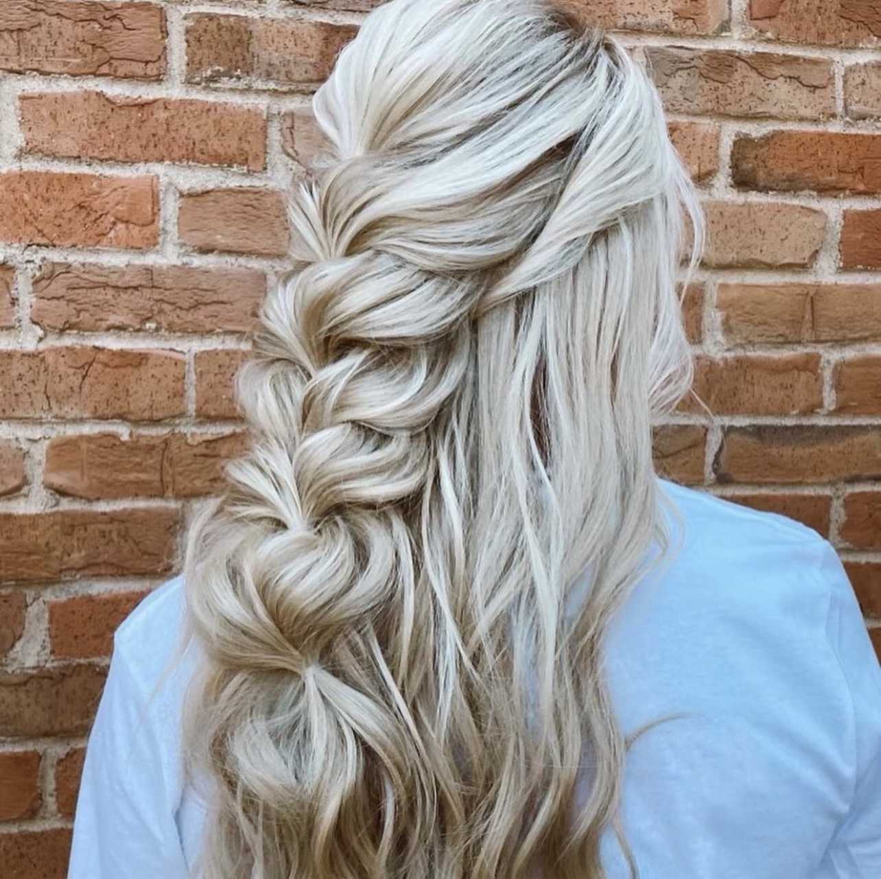 woman with light blonde hair with long half-up bridal braid hairstyle