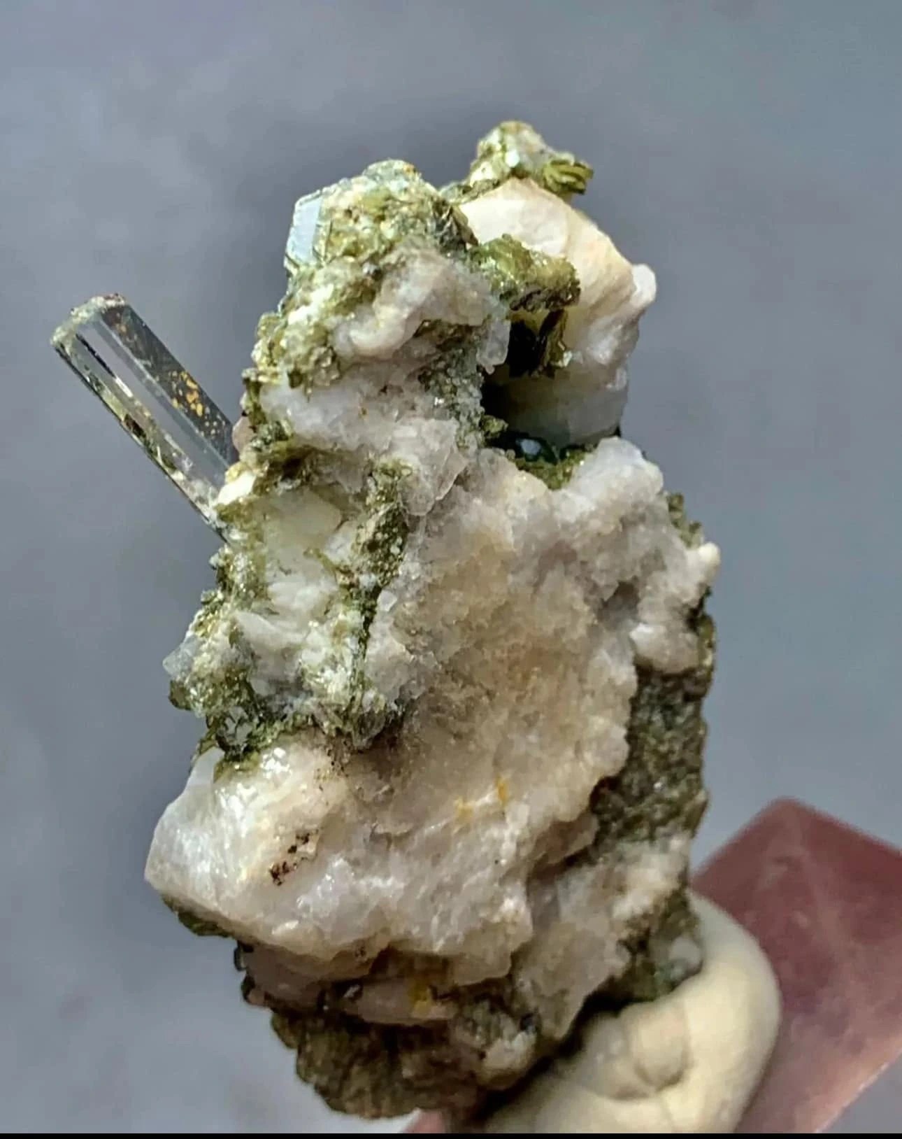 Metallic and white mineral cluster with a prominent blade crystal