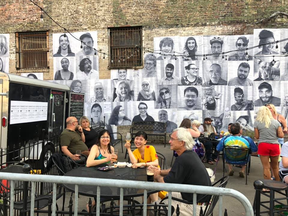 Photography collage of faces installed on exterior wall of Knoxville brewery