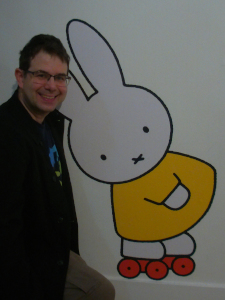 a large white cartoon rabbit in a yellow dress and on red roller skates, with a (non-cartoon) man incongruously next to it 